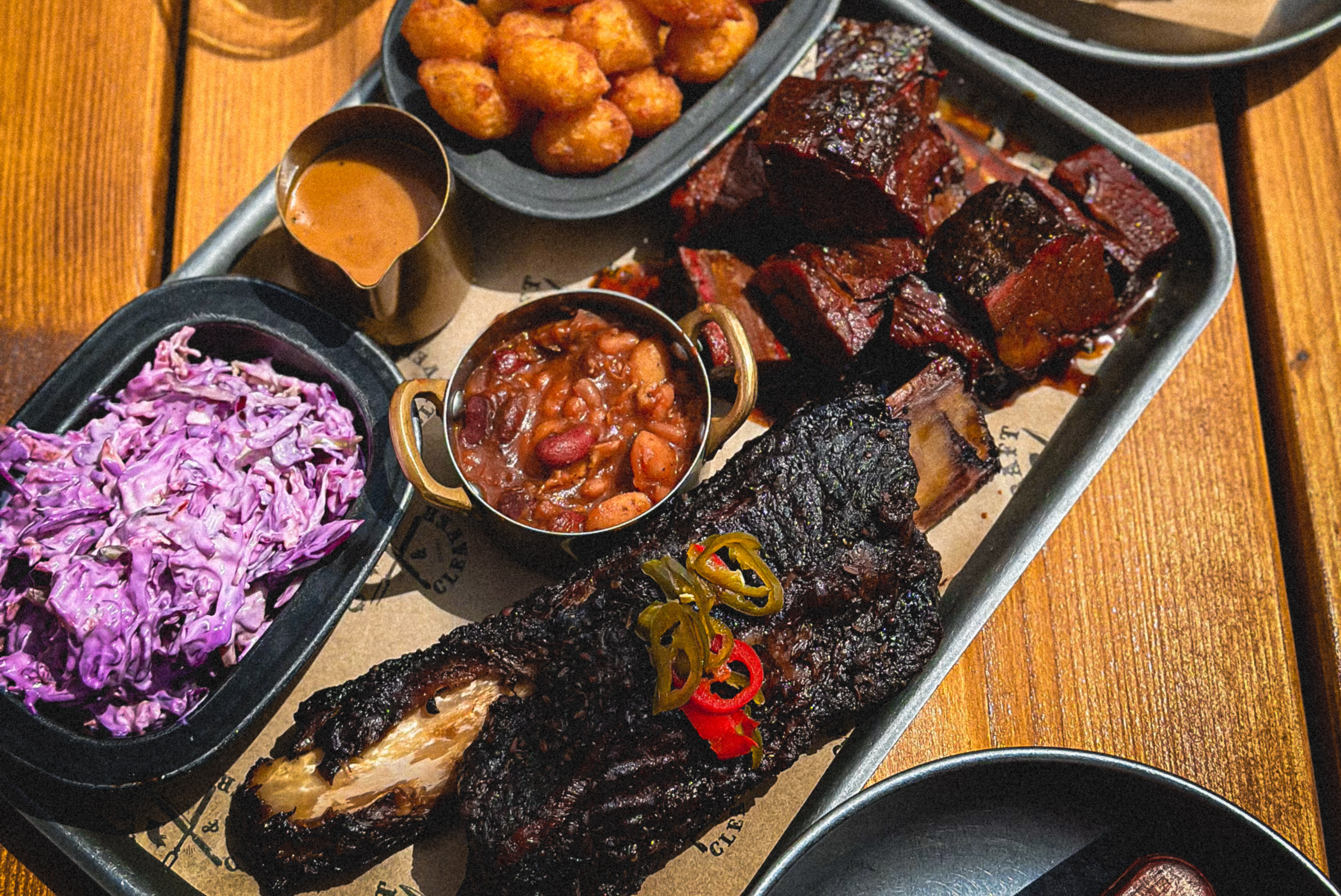 a tray of smoked meats with sides