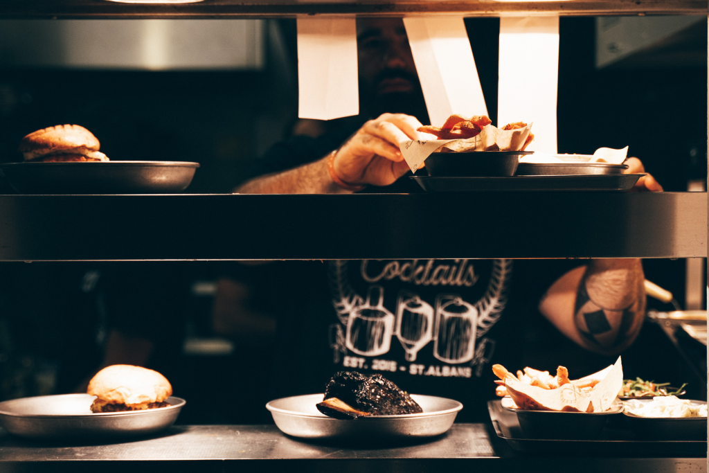 chef serving up food at the pass in Craft and Cleaver