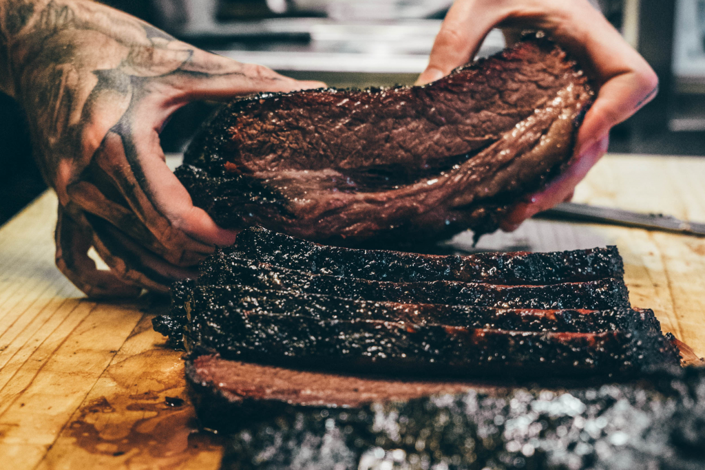 someone squeezing brisket and showing off the juices